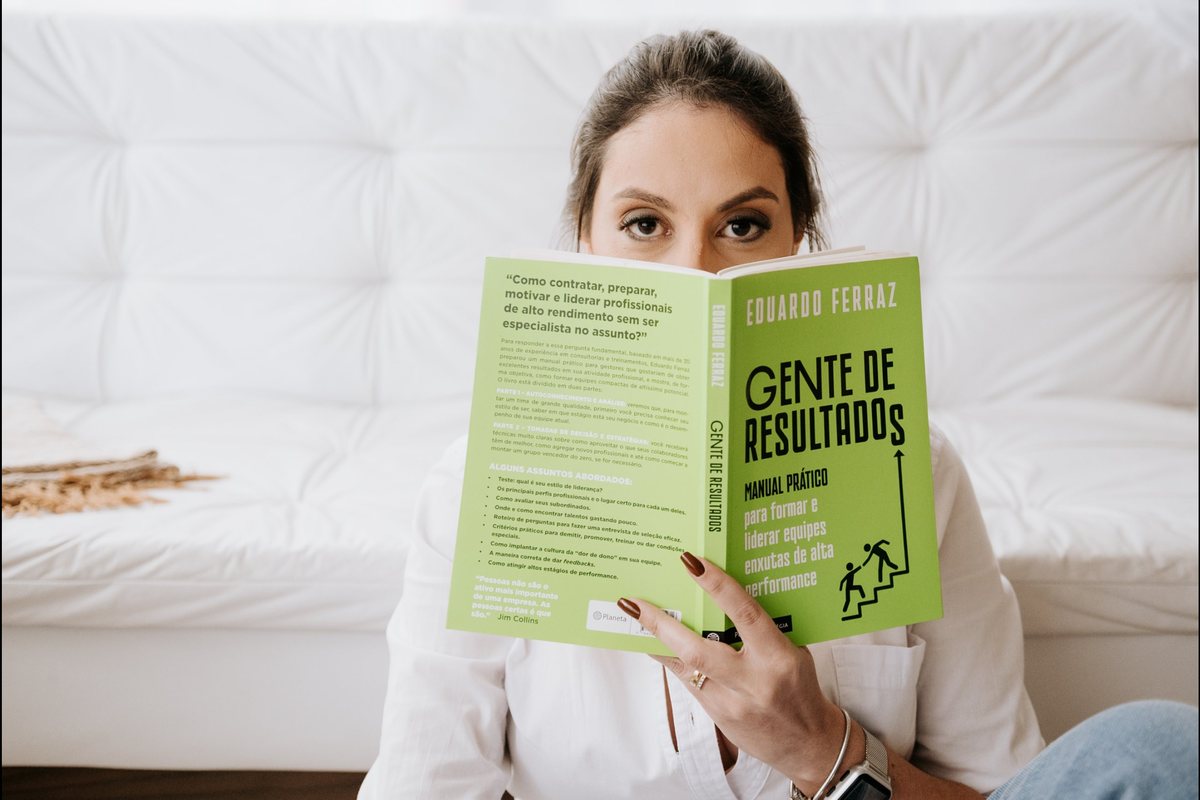 Areli Caparroz, fundadora da Agar Marketing, lendo em seu ambiente de trabalho